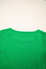 Green textured crew neck blouse with smocked detail and ruffle sleeves.