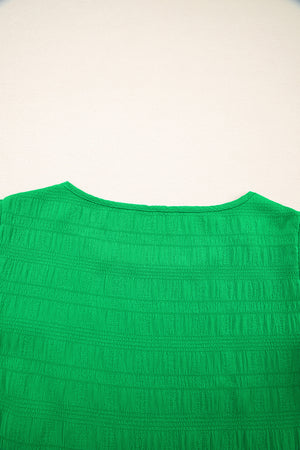 Green textured crew neck blouse with smocked detail and ruffle sleeves.