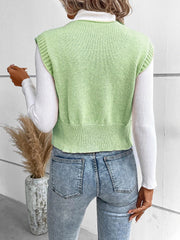 Light green knit vest with ribbed trim and a cropped hem, worn over a white turtleneck.