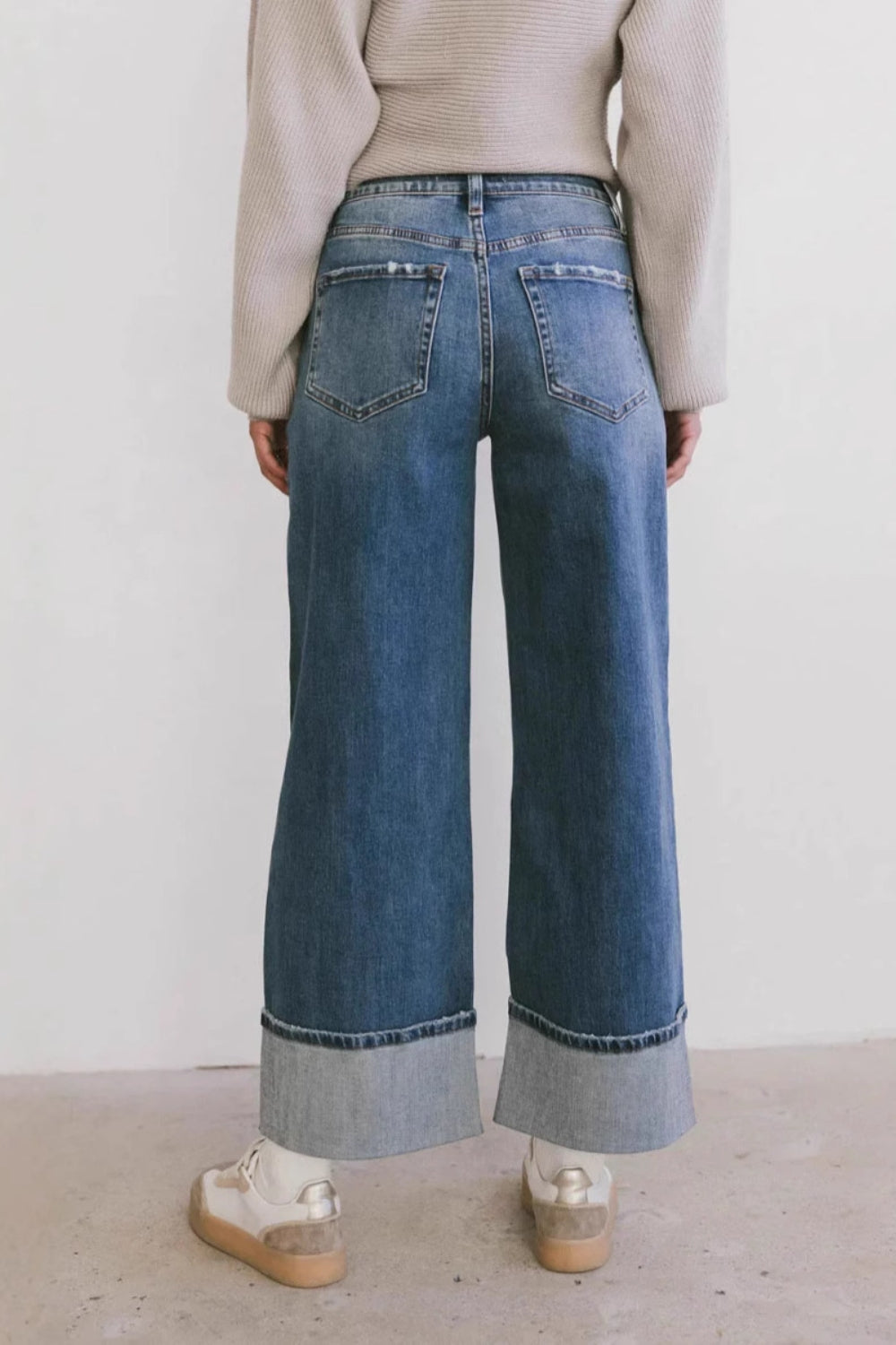 Wide-leg denim jeans in medium wash with contrast cuffs and distressed pockets.