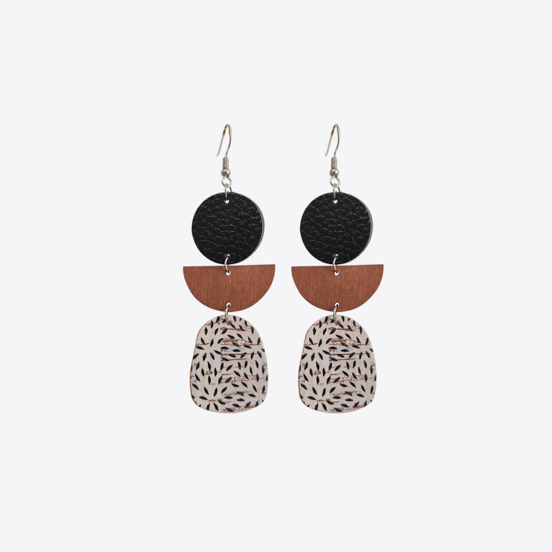 Geometric layered leather and wood earrings with abstract pattern.