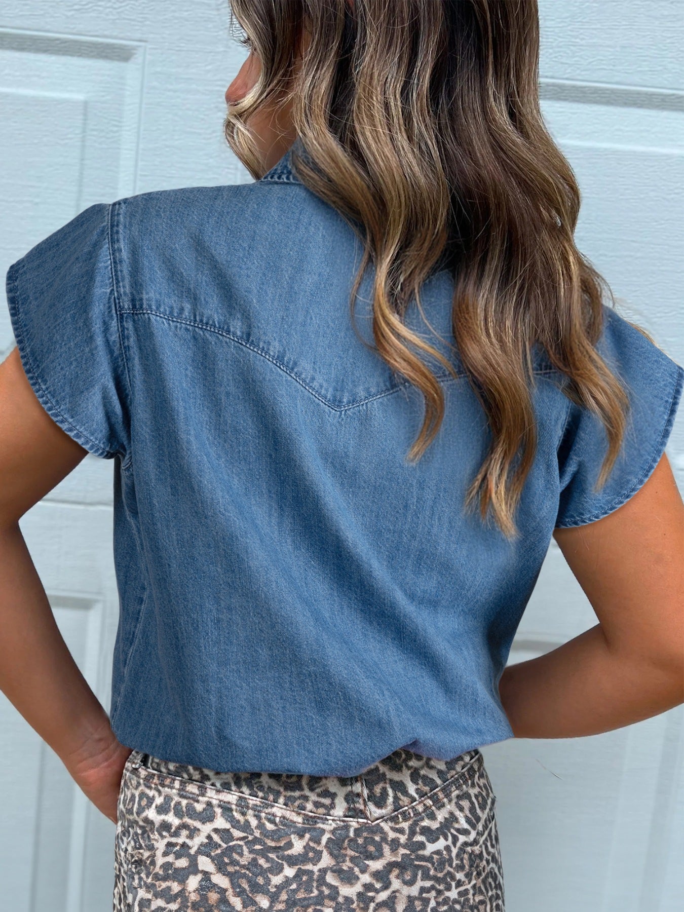 Denim button-up shirt with short sleeves and western yoke detail.