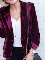 Burgundy velvet blazer with button front and notched lapel, styled with a white top.