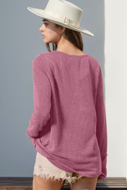 Pink waffle knit henley shirt with thumbhole cuffs and a relaxed fit.