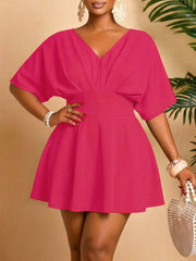 Plus-size pink mini dress with V-neck, dolman sleeves, and flared skirt.
