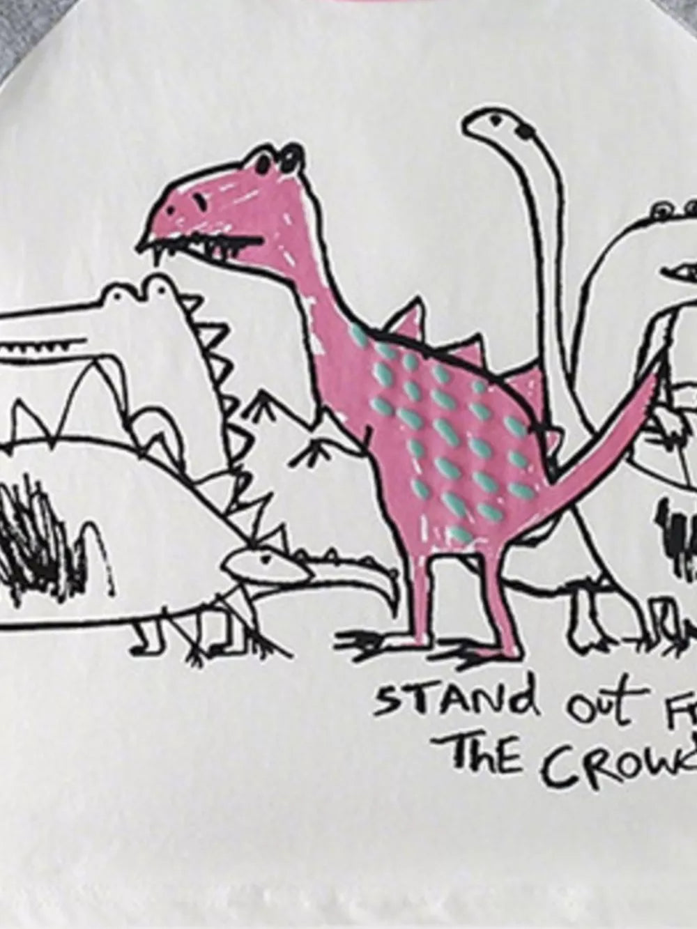 Toddler t-shirt with playful dinosaur print, featuring a pink dinosaur with teal dots and text.