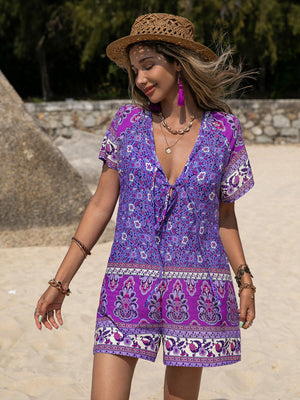 Purple floral print V-neck romper with tie front and short sleeves.