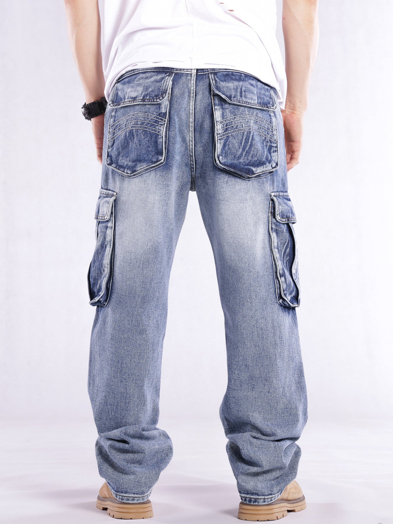 Relaxed fit light wash denim cargo jeans with flap pockets and contrast stitching.
