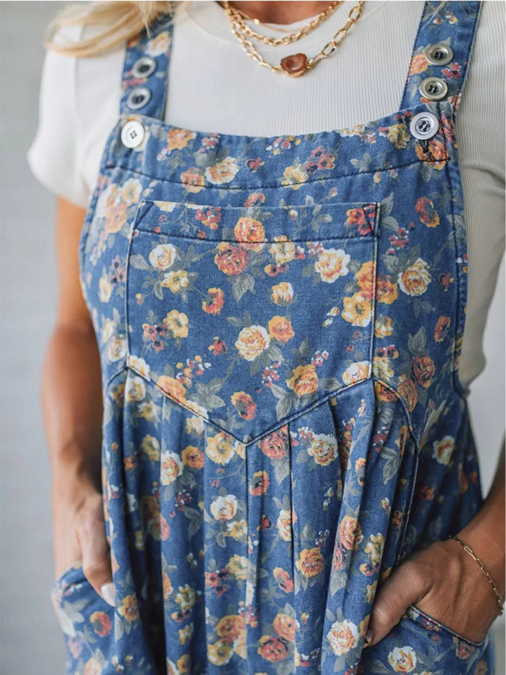 Floral denim overalls with adjustable straps and a chest pocket.