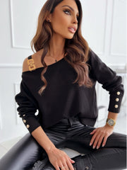 Black off-shoulder knit top with gold buckle detail on one strap and button details on sleeves.