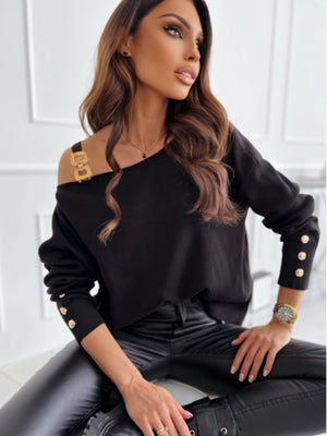 Black off-shoulder knit top with gold buckle detail on one strap and button details on sleeves.