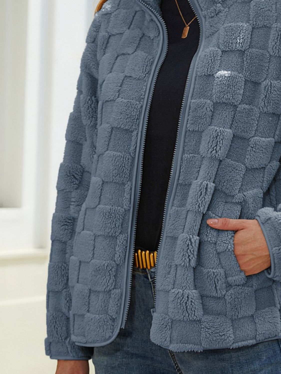 Textured grid zip-up jacket in grey, with a fuzzy fleece material and zip pockets.