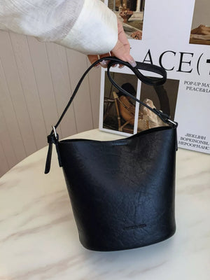 Black distressed vintage bucket crossbody bag with adjustable strap