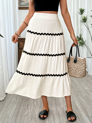 Elegant tiered midi skirt in beige with black wavy trim.