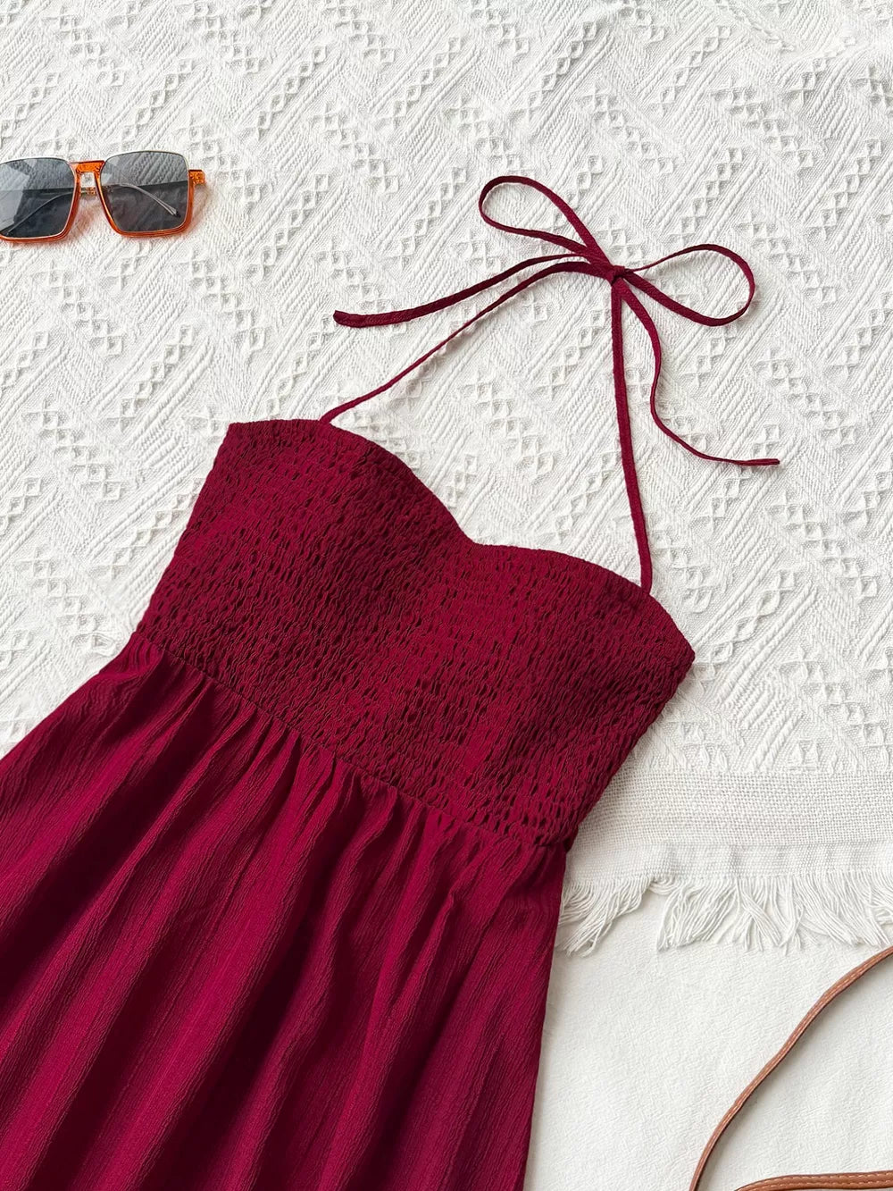 Burgundy halter neck maxi dress with smocked bodice and tie straps.