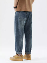 Men's blue washed stretch denim jeans with cuffed hems and back pockets.