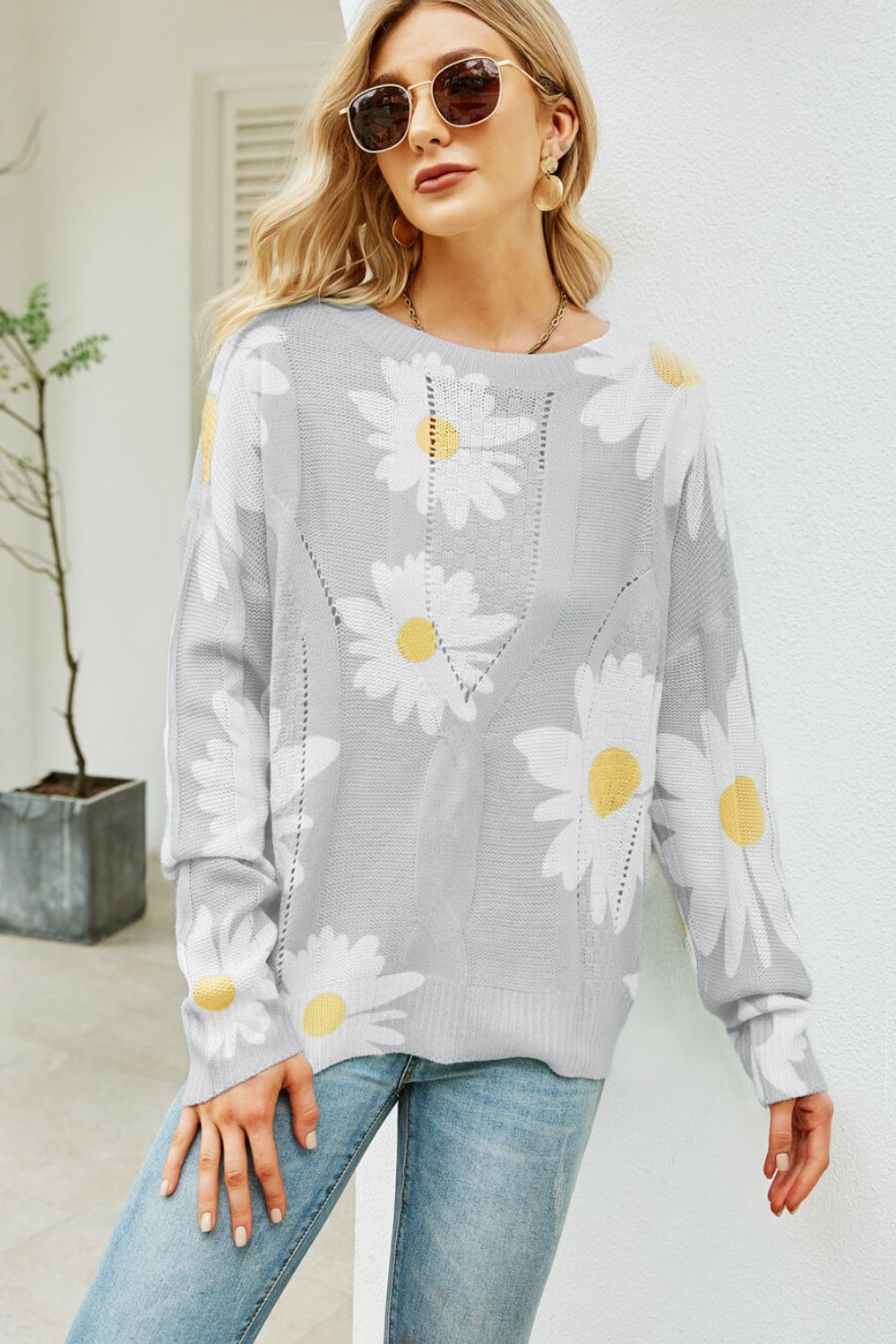 Light gray intarsia knit sweater with white daisy pattern, crew neck, and cable knit details.