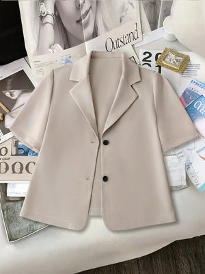 Light khaki short-sleeve tailored blazer jacket with two black buttons and notched lapels.
