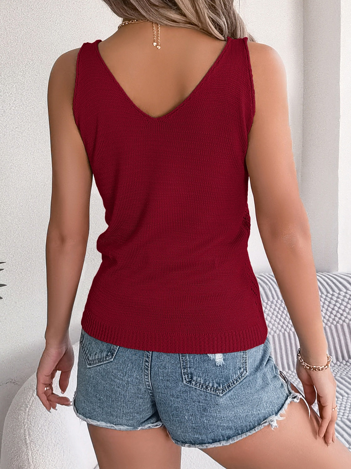 Burgundy knit vest with V-neck and ribbed texture, styled with denim shorts.