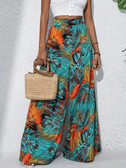 Tropical leaf print palazzo trousers in teal, orange, and black.