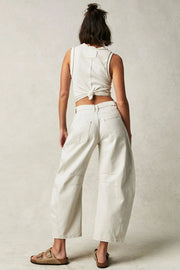 Cream denim barrel leg jeans with patch detail and frayed hem.