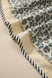 Leopard print mini dress with beige cotton blend fabric and black and white striped trim detail.