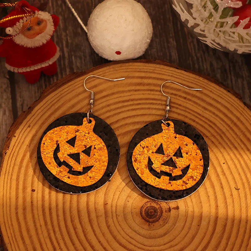Glitter pumpkin Halloween dangle earrings in tangerine orange with black backing.