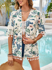 Tropical print kimono in pastel yellow with tassel trim and short sleeves.