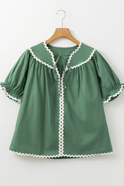 Moss green blouse with puff sleeves, tie neck, and white scalloped trim details.