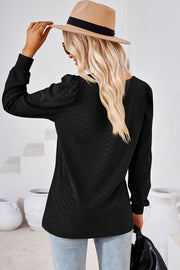Black diamond-textured puff sleeve top with a crew neck, shown from the back.