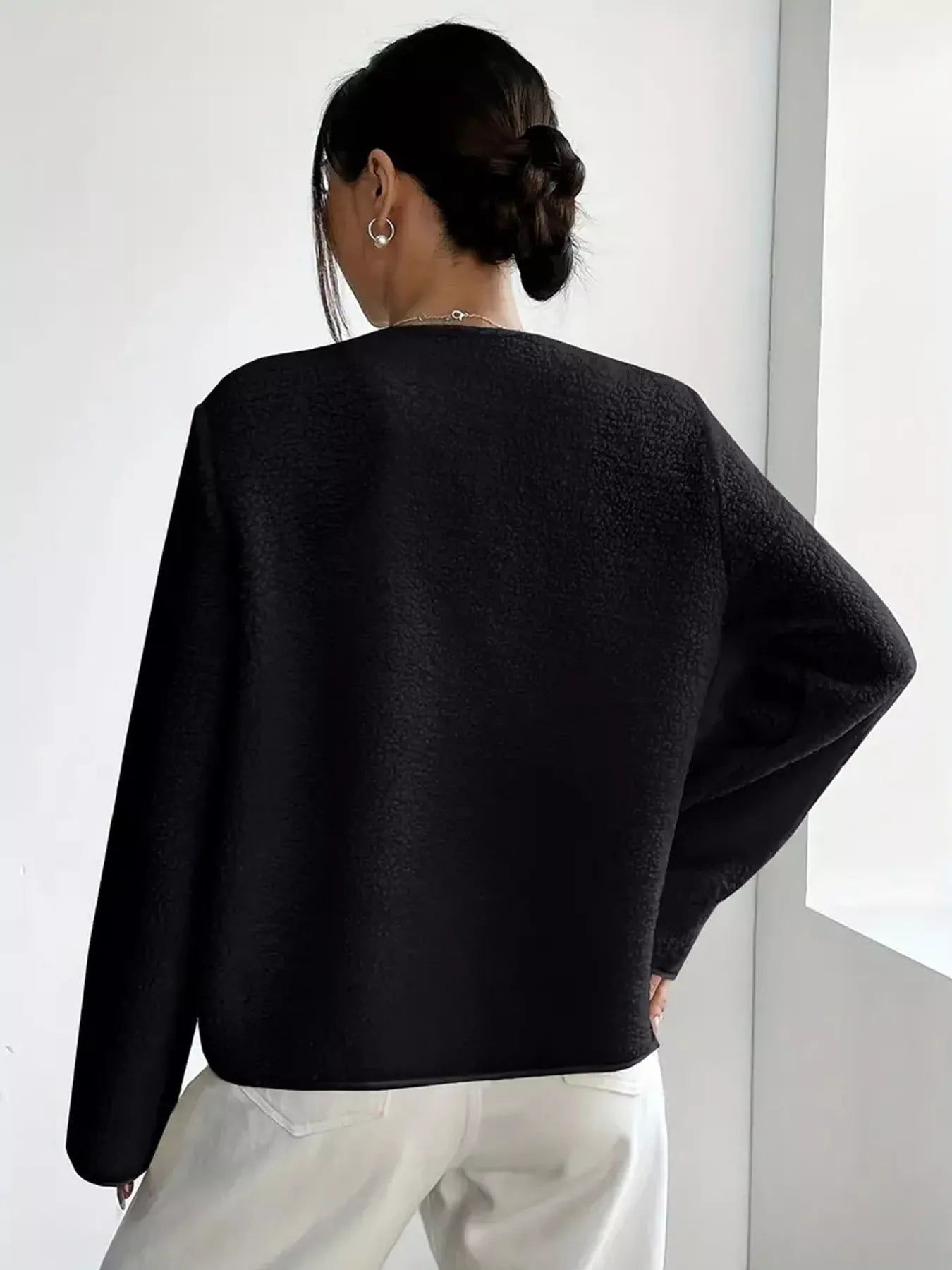 Black textured button-up fleece outerwear with long sleeves and a crew neckline.