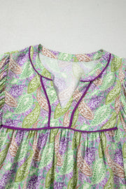 Paisley print puff sleeve blouse with purple trim and V-neck.
