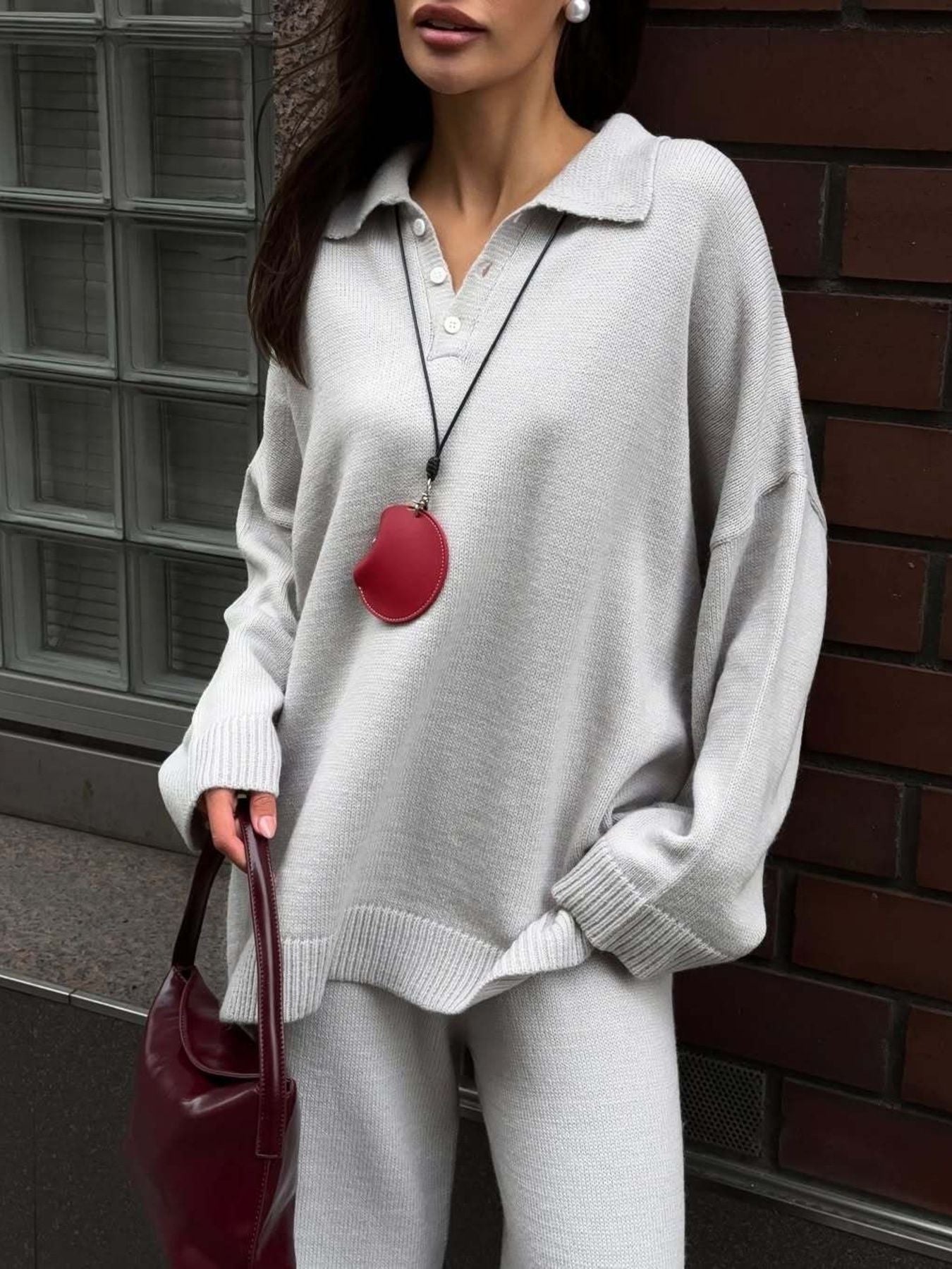 Grey knit polo sweater with button detail and wide-leg pants.