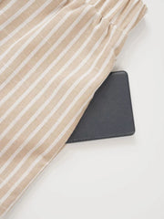 Chic high-waisted striped wide-leg pants in beige and white, showing pocket detail.