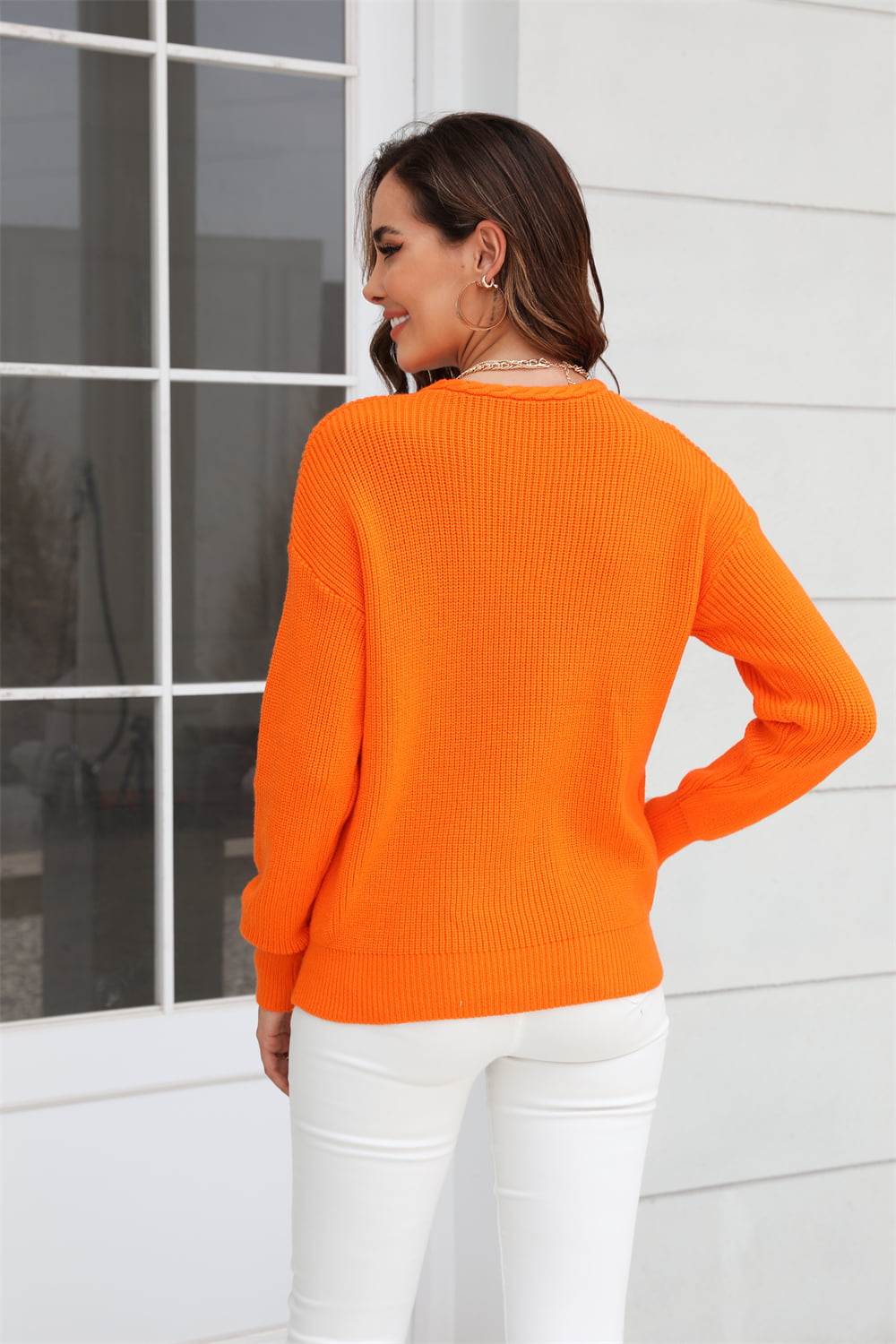 Orange ribbed knit V-neck sweater with long sleeves and a relaxed fit.