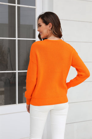 Orange ribbed knit V-neck sweater with long sleeves and a relaxed fit.
