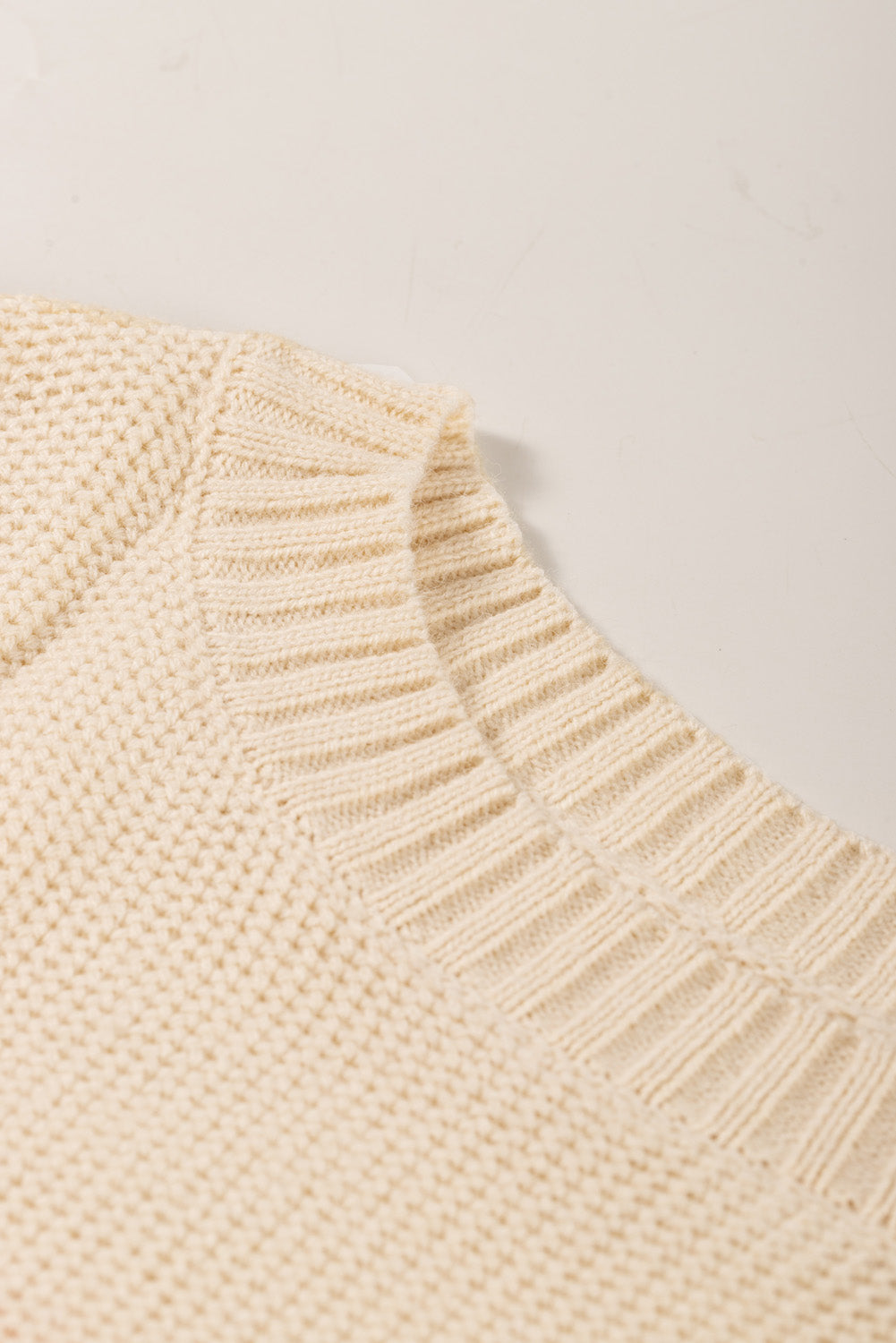 Cream ribbed knit pullover sweater with textured knit detail and ribbed neckline.