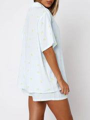 Light Blue striped pajama set with yellow floral print, collared button-up top and shorts.