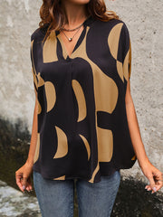Black abstract print batwing blouse with V-neck and short sleeves.