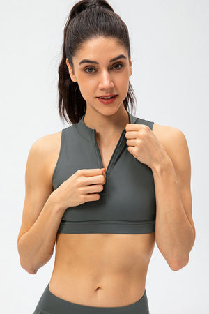High-neck zip-front active crop top in gray, sleeveless, with a partial zipper detail.