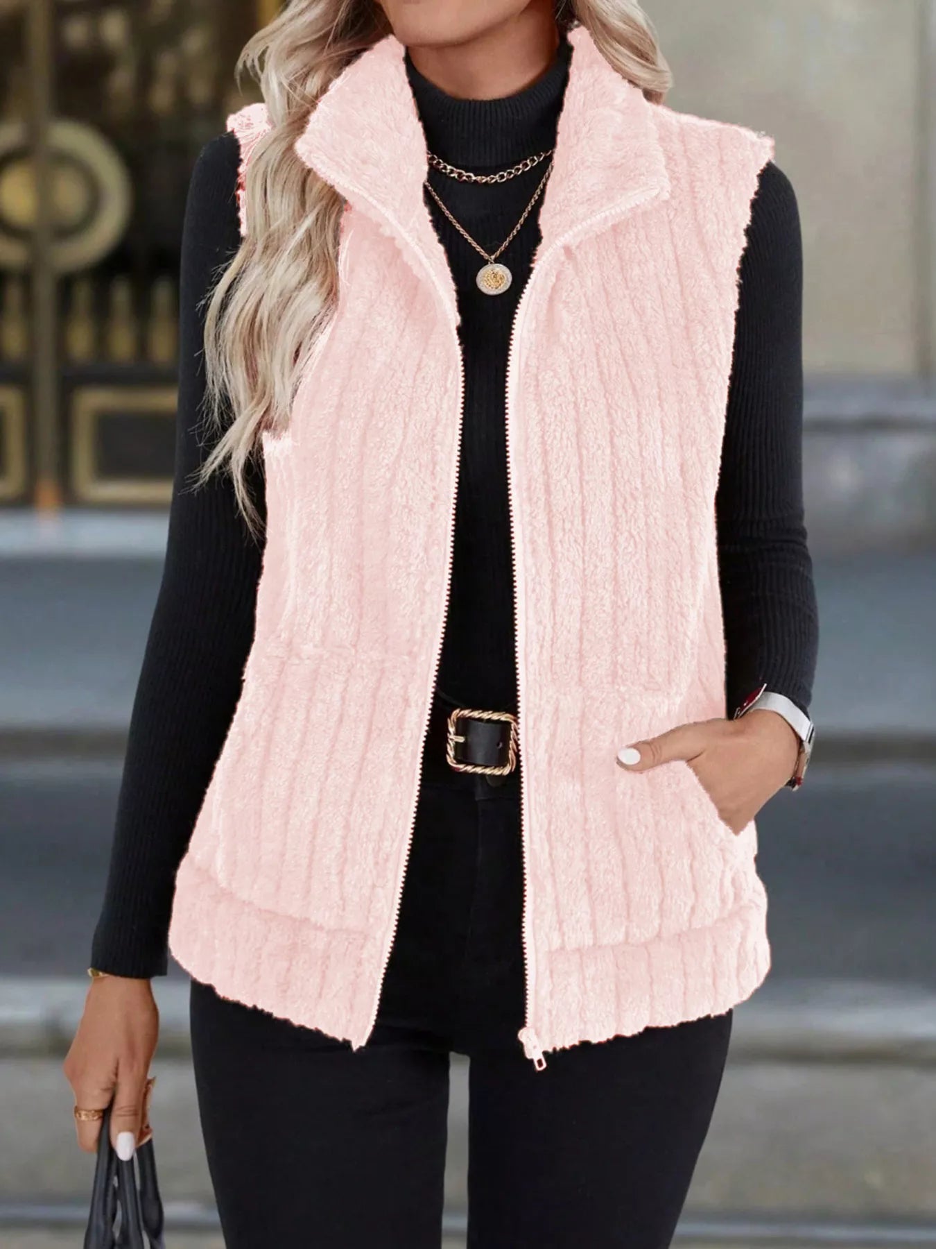 Pink fuzzy fleece zip-up vest with pockets and a stand-up collar.