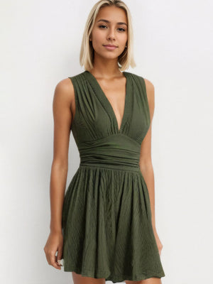 Textured ribbed plunge romper in army green with a cinched waist and flared skirt.