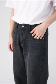 Black denim jeans with a relaxed fit and visible front pockets.