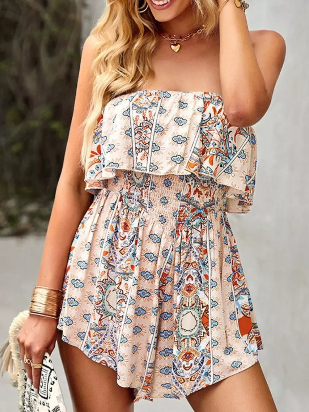 Boho romper with smocked waist and ruffled strapless neckline in a beige paisley print.