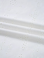 White cotton blouse with delicate eyelet embroidery and ruffled details.