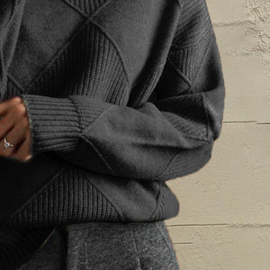 Black diamond knit turtleneck pullover with ribbed cuffs and textured panels.