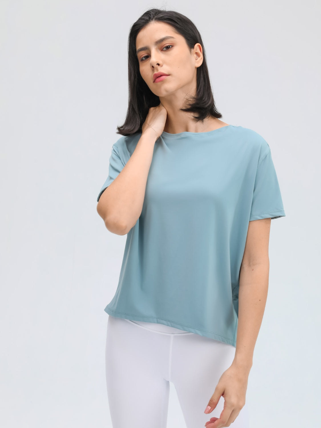 Relaxed fit dusty blue performance tee with short sleeves and a boat neckline.