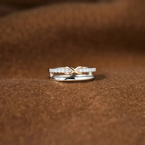 Silver infinity knot ring set with diamonds on a brown textured background