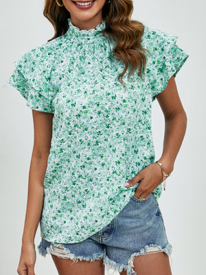 Light green floral blouse with ruffled neckline and flutter sleeves.
