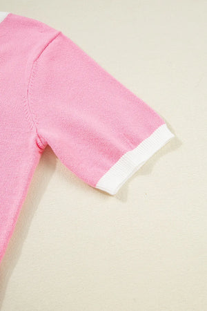 Pink knit top with white contrast trim on short sleeves.